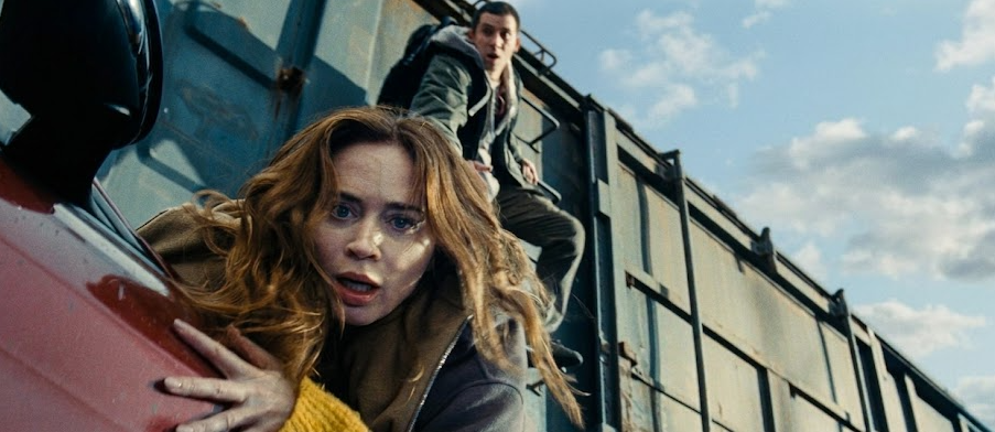 mage of Margaret (Emily Blunt) narrowly hanging on to a train. Image from the movie Disclosure Day, directed by Steven Spielberg. Movie review by Garry Murdock.