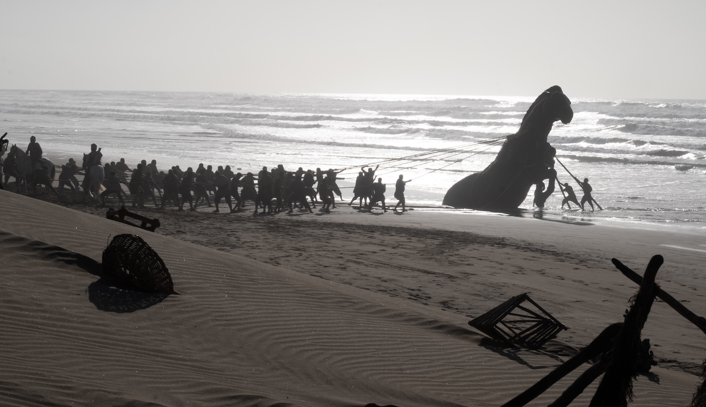 Image from the film The Odyssey. Soldiers pulling a Trojan Horse upright.